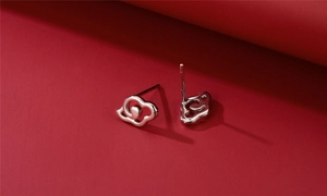 Close-up of S925 sterling silver cloud stud earrings on a dark red background