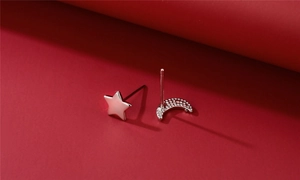 Close-up of asymmetric S925 silver star and moon earrings with pavé zircon stones