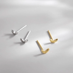 Minimalist gold and silver four-leaf clover stud earrings set with mirror polish