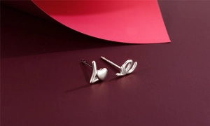 Close-up of S925 silver stud earrings with L and E letter charms and heart detail