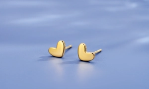 Detailed view of heart-shaped gold studs with premium mirror polished finish surface