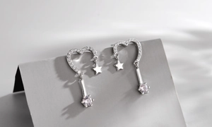 Detail of silver heart earrings with hanging star and cubic zirconia long drop pendants