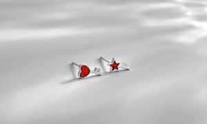 Dettaglio macro di orecchini a chiave asimmetrici in argento con smalto rosso