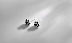 Macro shot of S925 sterling silver cat paw earrings with black enamel and hallmark