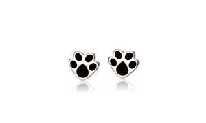 Detailed view of silver cat paw earrings with black enamel center and mirror reflection