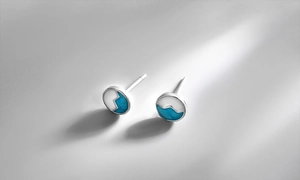 Detail of round S925 silver stud earrings with blue and white enamel wave patterns
