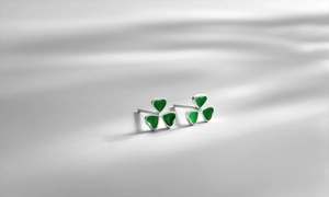 Dettaglio macro di orecchini a trifoglio in argento con petali in smalto verde