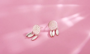 Detail of s925 sterling silver dreamcatcher earrings with feather charms on pink background