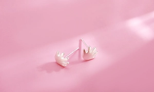 Detail of cute silver hand palm stud earrings with matte texture on pink background