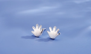 Macro shot of 925 sterling silver hand-shaped stud earrings with a brushed matte finish