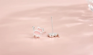 Gros plan détaillé du poinçon S925 sur les boucles d'oreilles chat roses asymétriques