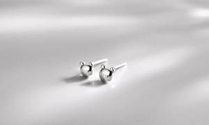 Macro detail of 3D bear stud earrings in polished S925 sterling silver with glossy finish