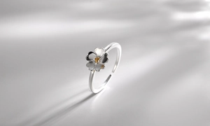 Dettaglio anello a fiore in argento S925 con stame dorato e fascia aperta regolabile