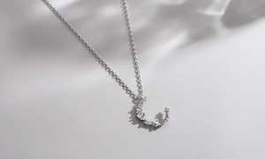 Close-up of crescent moon pendant necklace with shimmering marquise and round zirconias
