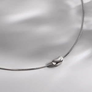 Elegant S925 sterling silver bean pendant necklace with polished finish on silk