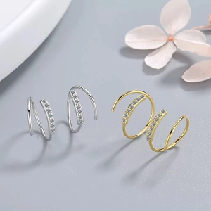 Elegant gold and silver spiral hoop earrings with single row diamonds on light grey background