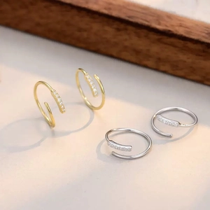 Minimalist spiral hoop earrings with pavé zircons in gold and silver finishes