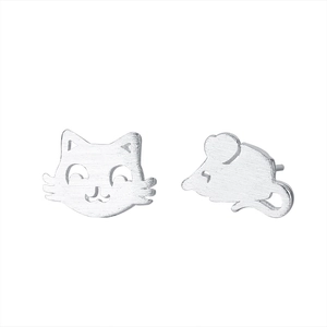 Close-up of asymmetrical cat and mouse studs with brushed silver metal texture