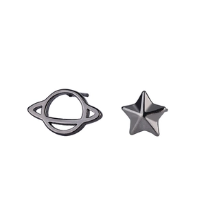 Macro detail of asymmetrical planet and star stud earrings in polished gunmetal finish