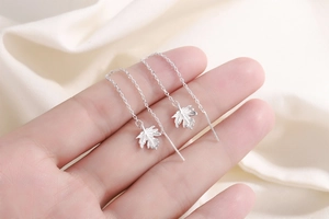 Macro shot of maple leaf tassel earrings showing delicate silver chain and leaf detail