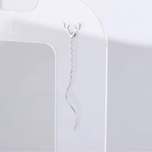 Silver antler drop earrings with delicate long chains and wavy pendants on grey background