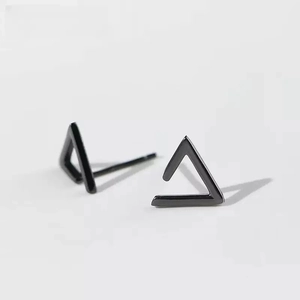 Minimalist black geometric triangle stud earrings with matte finish on grey background
