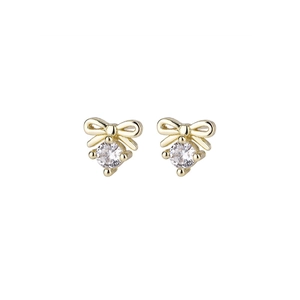Gold bow earrings with round cubic zirconia stones on a minimalist white background