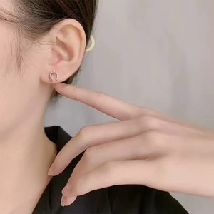 Elegant silver horseshoe stud earrings with sparkling cubic zirconia on model