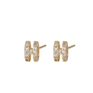 Macro detail of gold-plated H-shaped stud earrings with micro-pave zircon crystals