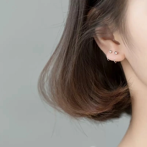 Minimalist silver stud and hoop earrings set on ear for modern everyday look