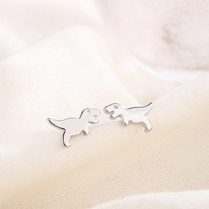 Cute S925 silver plated T-Rex dinosaur stud earrings on soft fabric background