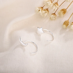 S925 sterling silver moon and star hook earrings with polished finish on linen fabric