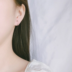Close-up of minimalist silver-plated double-line bead earrings on model's ear