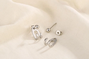 Detail of S925 silver double-line beaded jacket earrings set on beige fabric
