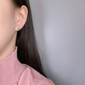 Minimalist S925 sterling silver ball drop earrings worn by model on a soft blue background