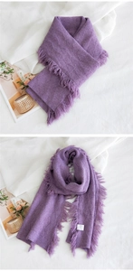 Détail de l'écharpe en tricot violet à motif losanges avec des bords à franges fins