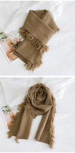 Détail d'une écharpe en maille marron à losanges avec bordures à franges et texture douce