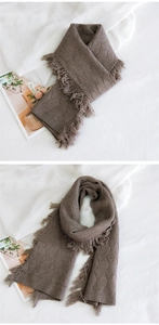 Détail de l'écharpe en tricot à losanges marron foncé avec franges douces et texture chaude