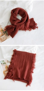 Détail d'écharpe en maille à carreaux losanges avec franges en couleur rouge brique