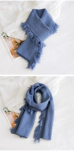 Détail d'une écharpe en tricot bleu avec motif à losanges et finitions à franges