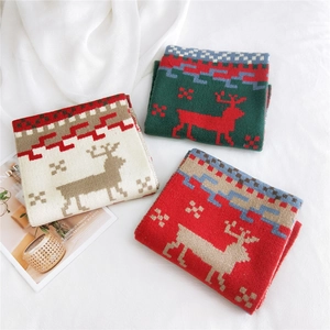 Christmas knit scarf featuring reindeer and snowflake patterns in red, green and white