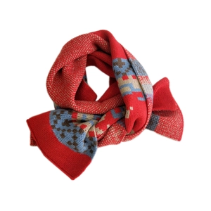 Thick red knitted winter scarf with festive plaid deer pattern and geometric design