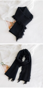 Détails de la maille à losanges et des franges de cette écharpe noire en tricot
