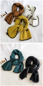 Detail of multi-color knitted scarves showing contrast stitching and soft texture