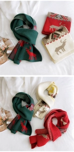 Close-up of Christmas knit scarf featuring festive reindeer patterns and jacquard texture