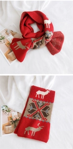 Detail of red Christmas scarf featuring white reindeer and snowflake knit patterns