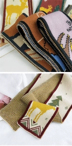 Detailed view of knitted jacquard scarf featuring elk and Christmas tree patterns