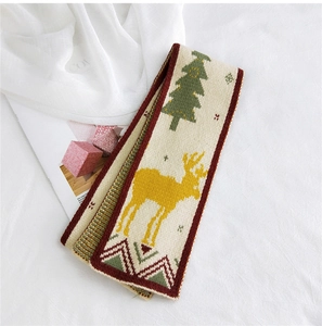 Macro detail of Christmas reindeer and tree patterns on festive knitted scarf