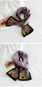 Close-up of knitted scarf showing purple and yellow geometric patterns and soft texture