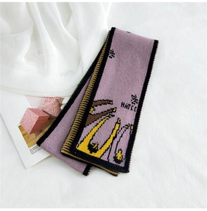 Close-up of lilac knitted scarf featuring cartoon deer pattern and thick texture